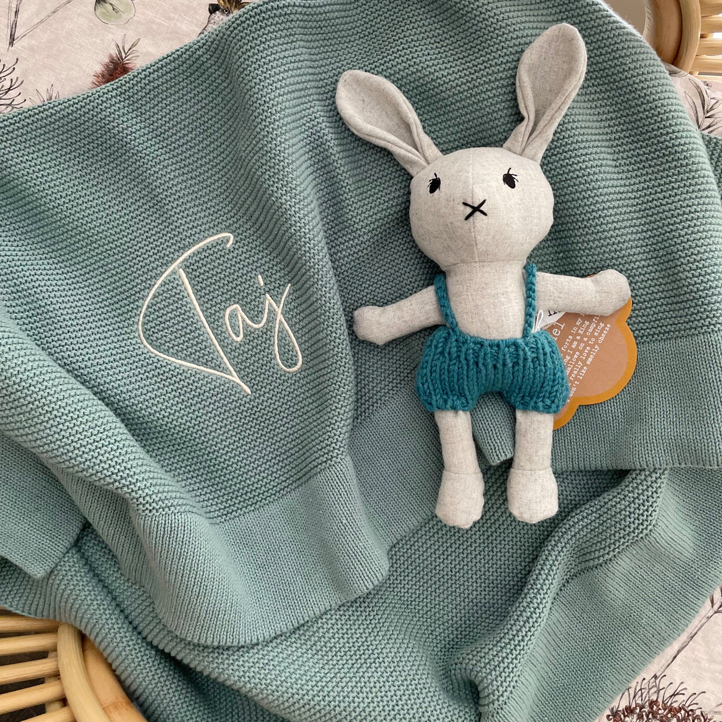 Seamist green coloured baby blanket with a toy rabbit